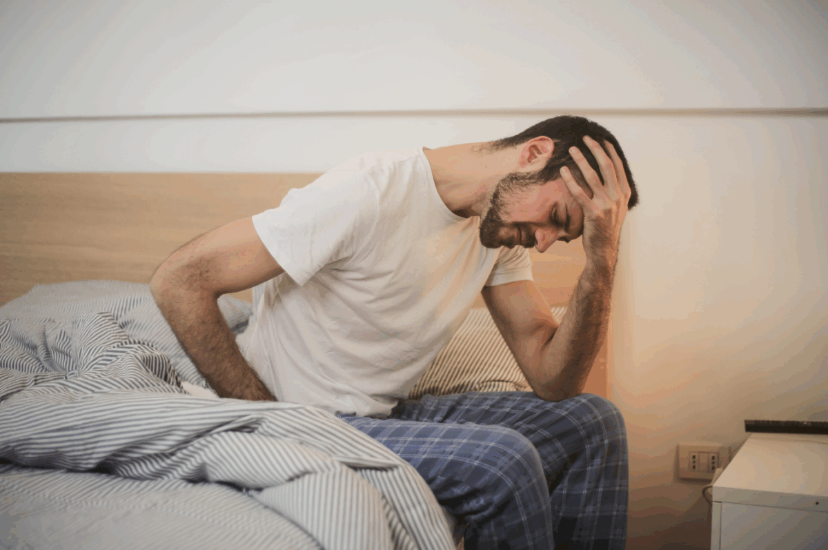 Tired man having a hard time getting out a bed